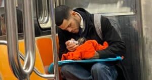 Man feeding kitten on subway