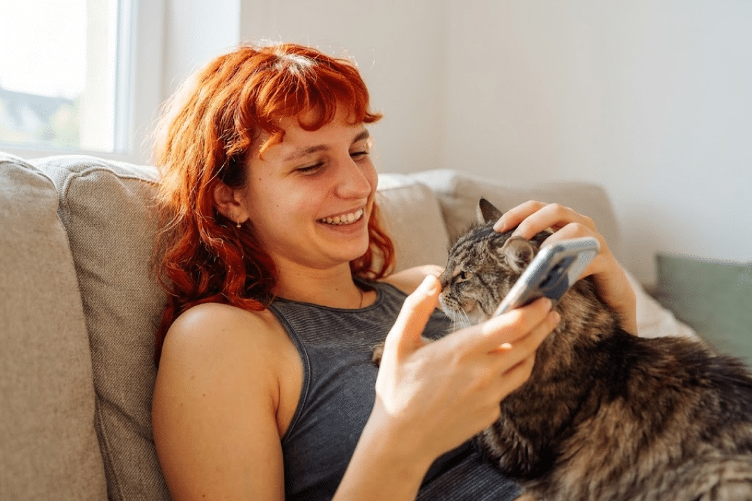 Meow Mobile woman with phone petting cat