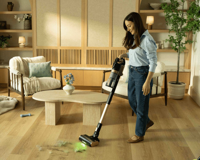 Woman using the Levoit VortexIQ Pro cordless stick vacuum on hardwood floors